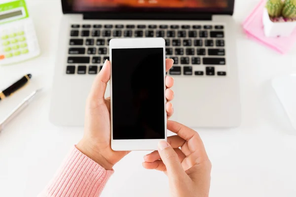 Mano Mujer Sosteniendo Teléfono Móvil Blanco Una Mesa Con Ordenador — Foto de Stock