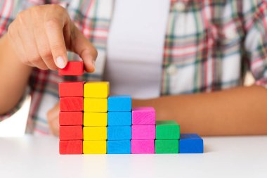 Başarı temel yapı kavramı. Kadın el renkli ahşap bloklar bir merdiven şeklinde koymak.
