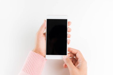 Kadın el Beyaz Masa arka plan üzerinde beyaz cep telefonu akıllı telefon tutarak.