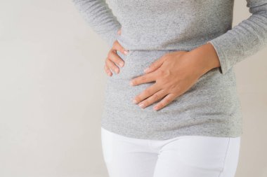 Genç kadın acı mide ağrısı sahip. Kronik gastrit. Karında şişkinlik kavramı.