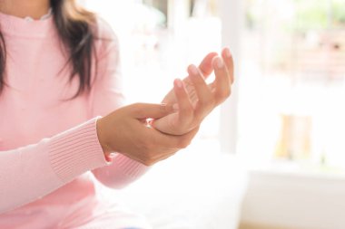 Koltukta oturan Closeup kadın onu bilek el yaralanması, acı hissetmiyor tutar. Sağlık ve tıp kavramı.