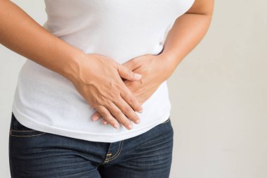 Genç kadın acı mide ağrısı sahip. Kronik gastrit. Karında şişkinlik kavramı.