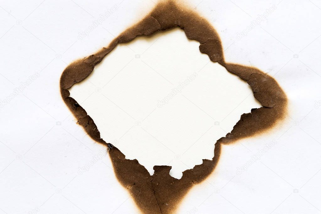 burned hole on piece of paper isolated on white background.