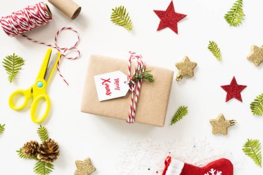 Noel arka plan kavramı. Noel hediye kutusu etiketi mesaj, kırmızı yıldız ve çam kozalakları ile üstten görünüm beyaz arka plan üzerinde.