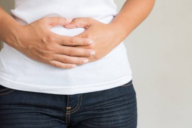 Genç kadın acı mide ağrısı sahip. Kronik gastrit. Karında şişkinlik kavramı.