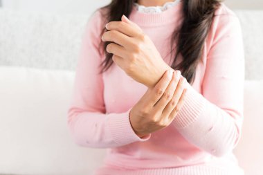 Koltukta oturan Closeup kadın onu bilek el yaralanması, acı hissetmiyor tutar. Sağlık ve tıp kavramı.