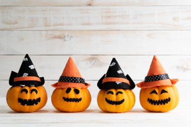 cadı şapkası yarasa Beyaz ahşap borad zemin üzerine sarı hayalet balkabağı. Cadılar Bayramı kavramı.