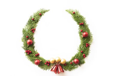 Noel ve yeni yıl kompozisyon. Beyaz arka plan üzerinde çam dalları, çam kozalakları, kırmızı meyveler ve çan üstten görünüm.