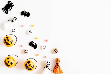 Beyaz ahşap zemin üzerinde beyaz ve sarı hayalet kabaklar yarasa örümcek mumya jöle solucan ve hediye kutusu ile en iyi görünümü. Cadılar Bayramı kavramı.