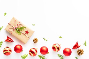 Noel ve yeni yıl kompozisyon. Ahşap beyaz zemin üzerine hediye kutusu, çam kozalakları, kızıl yıldız ve çan üstten görünüm.