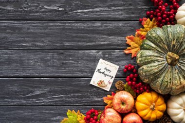 Yukarıdan Sonbahar akçaağaç balkabağı ve kırmızı çilek ile eski ahşap artalan üzerinde bırakır. Şükran günü kavramı.