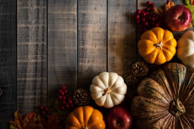 Yukarıdan Sonbahar akçaağaç balkabağı ve kırmızı çilek ile eski ahşap arka plan üzerinde bırakır. Şükran günü kavramı.