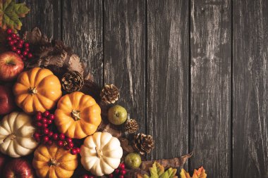 Yukarıdan Sonbahar akçaağaç balkabağı ve kırmızı çilek ile eski ahşap arka plan üzerinde bırakır. Şükran günü kavramı.