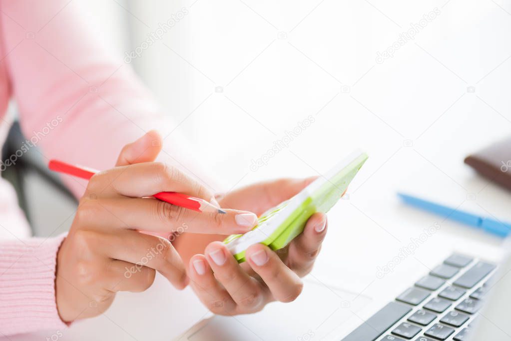 woman hand holding red pencil and working with calculator, business document and laptop computer notebook