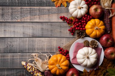 Yukarıdan Sonbahar akçaağaç, kabak, elma, Mısır ve kırmızı meyveler ile eski ahşap arka plan üzerinde bırakır. Şükran günü kavramı.
