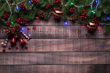 Noel arka plan kavramı. Noel hediye kutu kırmızı çorap çam dalları, çam kozalakları, kırmızı meyveler ve bell ile üstten görünüm eski ahşap zemin üzerine.