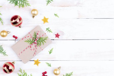 Noel arka plan kavramı. Noel hediye kutusu çam dalları, çam kozalakları, kırmızı meyveler ve bell ile üstten görünüm Beyaz ahşap masa arka plan üzerinde.