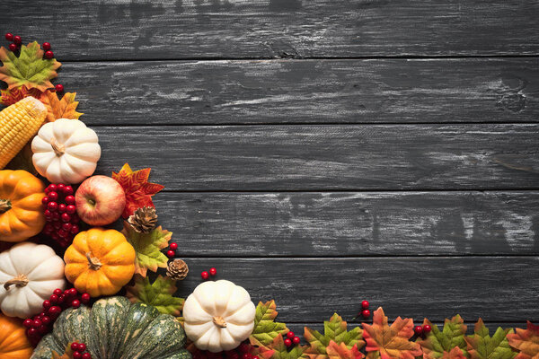 Вид сверху на листья картона Autumn с тыквой и красными ягодами на старом деревянном фоне. Концепция Дня благодарения
.