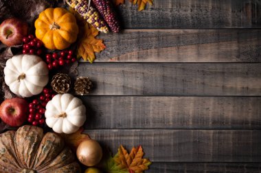 Yukarıdan Sonbahar akçaağaç, kabak, elma, Mısır ve kırmızı meyveler ile eski ahşap arka plan üzerinde bırakır. Şükran günü kavramı.