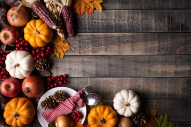 Yukarıdan Sonbahar akçaağaç, kabak, elma, Mısır ve kırmızı meyveler ile eski ahşap arka plan üzerinde bırakır. Şükran günü kavramı.