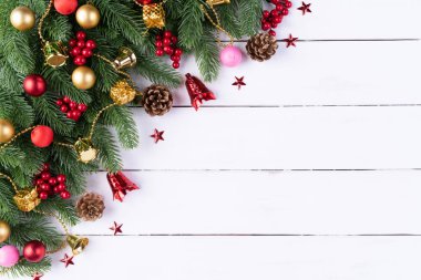 Noel arka plan kavramı. Noel hediye kutu kırmızı topları çam dalları, çam kozalakları, kırmızı meyveler ve bell ile üstten görünüm eski ahşap zemin üzerine.