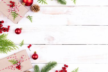 Noel arka plan kavramı. Noel hediye kutusu çam dalları, çam kozalakları, kırmızı meyveler ve bell ile üstten görünüm Beyaz ahşap masa arka plan üzerinde.