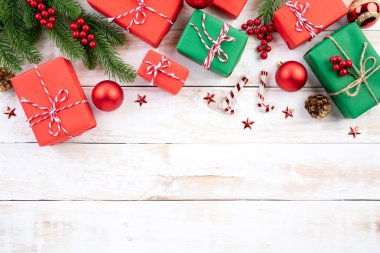 Noel arka plan kavramı. Yeşil ve kırmızı hediye kutusu ile Ladin dalları, çam kozalakları, kırmızı meyveler Noel görünümünü üst ve beyaz ahşap arka plan üzerinde çan.