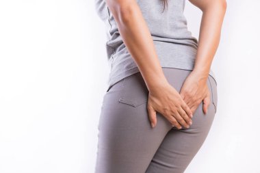 Hemoroid ve onun alt karın ağrısı olan çünkü tutan el muzdarip bir kadın. Sağlık kavramı.