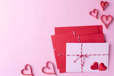 Sevgililer günü ve aşk kavramı. Kırmızı kalp ve kırmızı mektup kapak pembe bir arka plan üzerinde pembe.