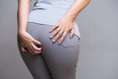 Hemoroid ve onun alt karın ağrısı olan çünkü tutan el muzdarip bir kadın. Sağlık kavramı.