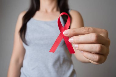 Tatlı kadın el holding kırmızı kurdele HIV, Dünya AIDS günü bilinçlendirme şerit. Sağlık ve tıp kavramı.
