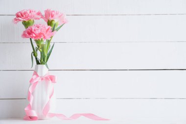 Sevgililer günü ve aşk kavramı. Ahşap harflerle kelime beyaz zemin üzerine yazılmış aşk şekillendirme vazoda pembe karanfil çiçek.