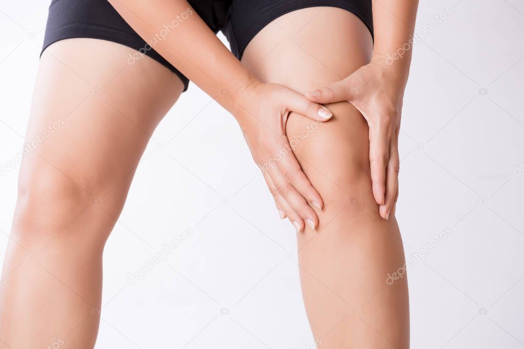 Runner sport knee injury. Closeup young woman in knee pain while running. Healthcare and medical concept.