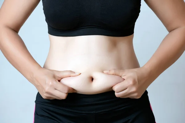 Gordura mão mulher segurando gordura da barriga excessiva. Saúde e mulher — Fotografia de Stock