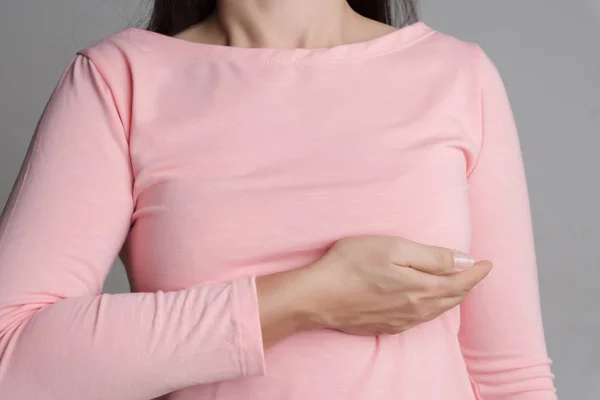 Mujer de la mano revisando bultos en su pecho en busca de signos de cáncer de mama — Foto de Stock