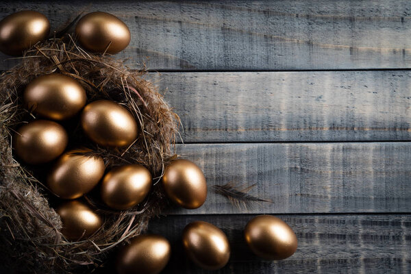 Happy easter! golden of Easter eggs in nest and Feather on woode