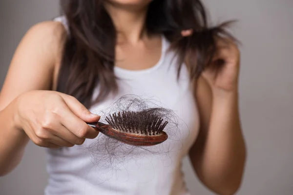 Healthy concept. Woman show her brush with long loss hair and lo