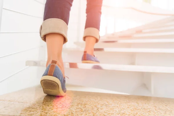 Mladé dospělé ženy, chůzi po schodech s sun sport poza — Stock fotografie