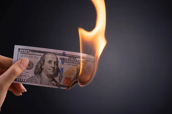 Donna mano in mano bruciore denaro in contanti dollaro — Foto Stock