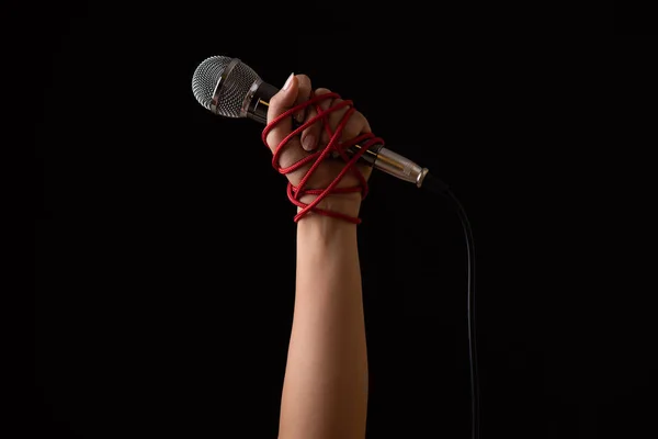 Woman hand with microphone tied with a red rope — 스톡 사진