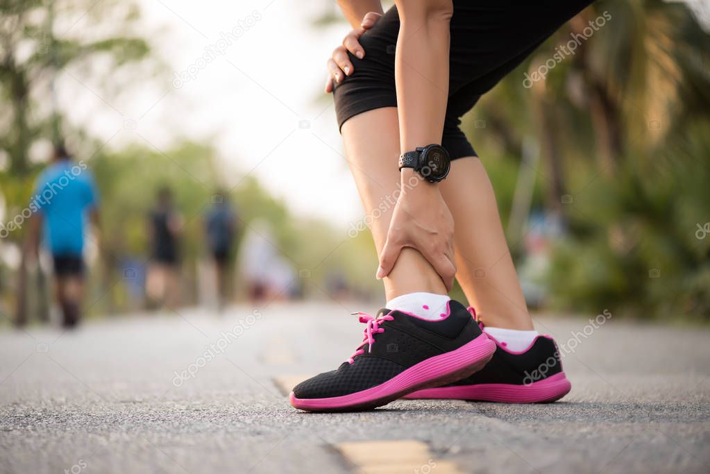 Woman suffering from an ankle injury while exercising. 