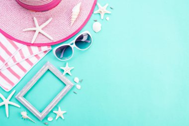 Plaj aksesuarları retro film kamera, resim çerçevesi, güneş gözlüğü, denizyıldızı, plaj şapkası ve yaz tatili ve tatil konsepti için yeşil arka plan üzerinde deniz kabuğu.