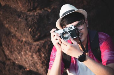 sırt çantası ile oung Man Fotoğrafçı Traveler onun kamera ile fotoğraf çekmek, tarihi bir yerde arka planda Büyük duvar. Yaşam tarzı ve seyahat konsepti.