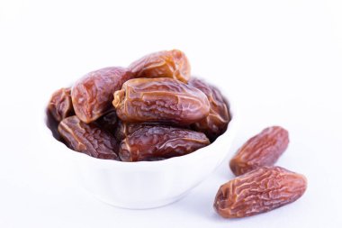 Ramazan yiyecek ve içecek konsepti. Beyaz arka plan üzerinde tarihler meyve kadar yakın.