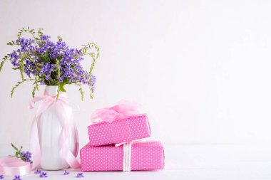 Mutlu anneler günü kavramı. Beyaz ahşap masa arka plan üzerinde mor çiçek ile Hediye kutusu.
