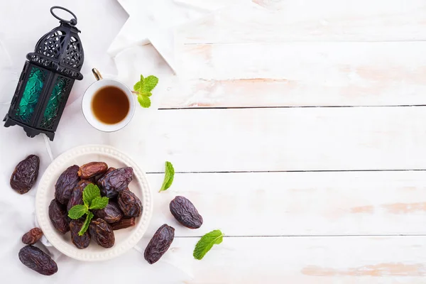 라마단 음식과 음료 개념입니다. 흰색 나무 테이블 배경에 날짜 과일과 민트 잎 차. 상단 보기, 플랫 레이. — 스톡 사진