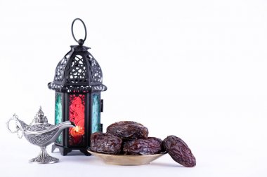 Ramazan yiyecek ve içecek konsepti. Arap lambası, ahşap tespih, hurma meyve ve beyaz arka plan aydınlatma ile Ramazan Fener.