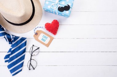 Mutlu babalar günü kavramı. Mavi kravat, güzel hediye kutusu, gözlük lü erkek şapkası ve beyaz ahşap masa arka planda retro film kamera üst görünümü. Düz yatıyordu.