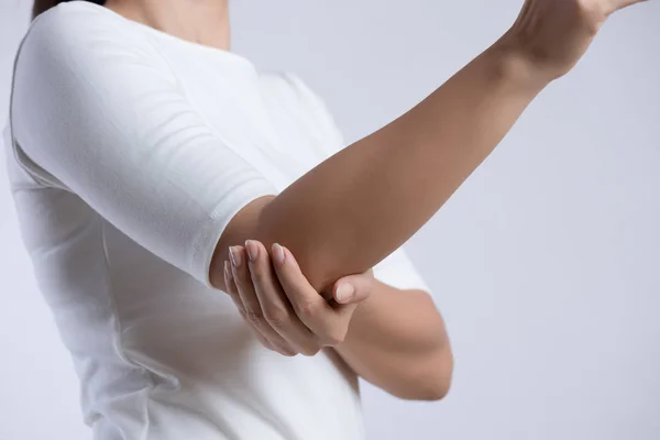 Närbild kvinnliga armbåge. Arm smärta och skada. Hälsovård och medicinsk koncept. — Stockfoto