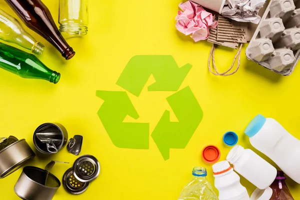Widok z góry różnych materiałów odpadowych z symbolem recyklingu na tle tabeli. Recykling, Światowy dzień środowiska i koncepcja eko — Zdjęcie stockowe